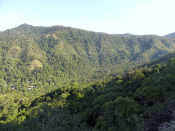 Hills with trees on the other side of the Barron Creek valley, viewed from the Kuranda Scenic Railway train near the Red Bluff rocks