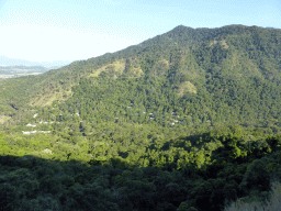 Hills with trees on the other side of the Barron Creek valley, viewed from the Kuranda Scenic Railway train near the Red Bluff rocks