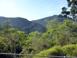 Hills with trees on the other side of the Barron Creek valley, viewed from the Kuranda Scenic Railway train near the North Peak