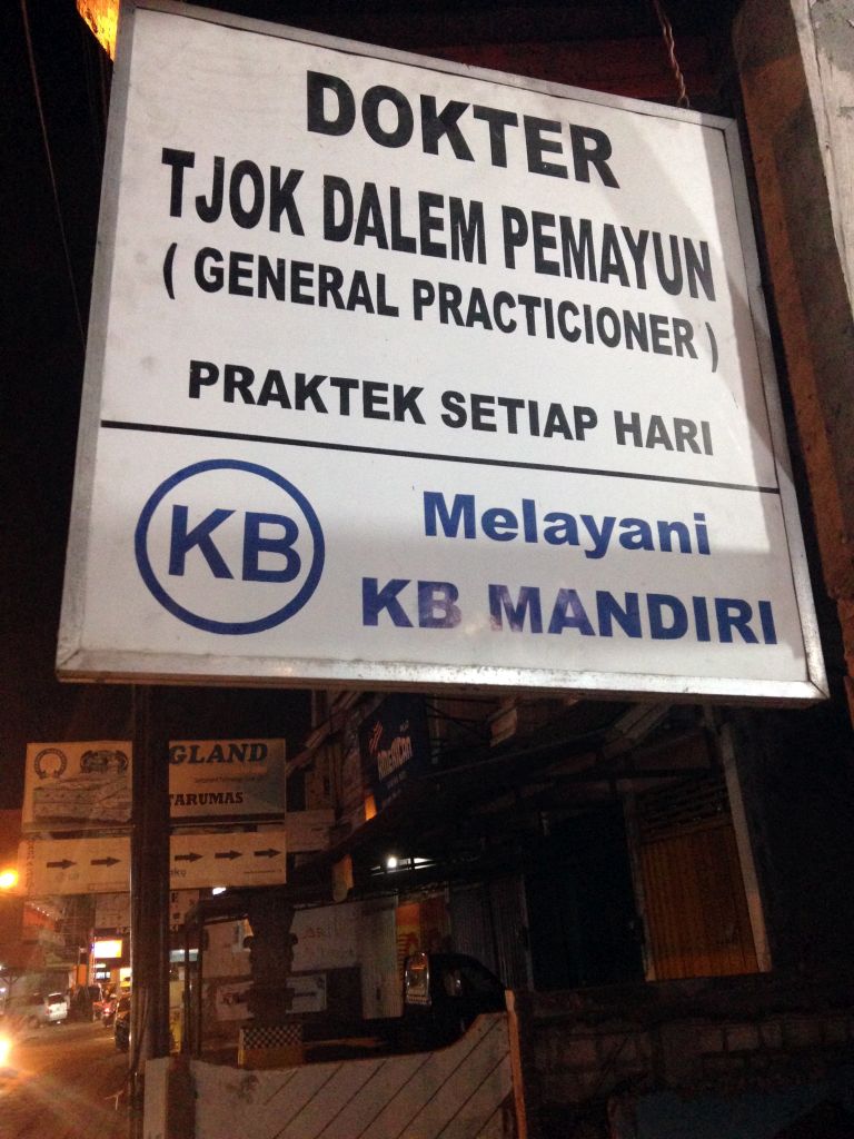 Sign of a doctor`s office at the Jalan Dewi Sartika street, by night