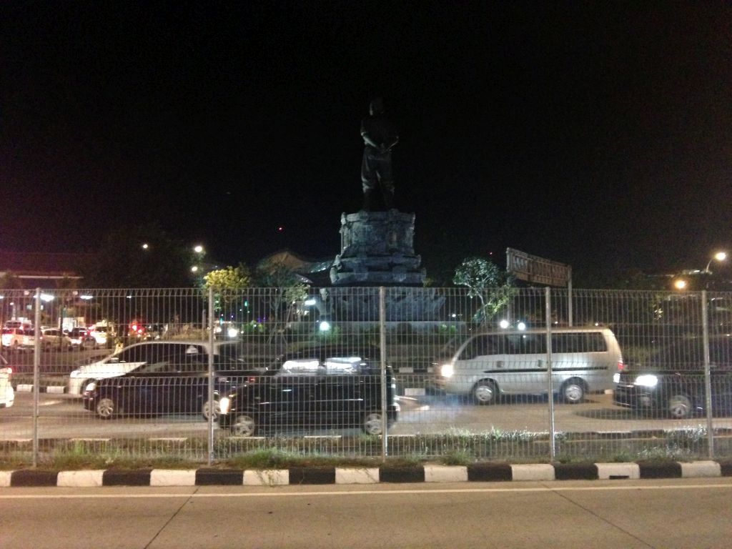 Back side of the statue of I Gusti Ngurah Rai at the northeast side of the Ngurah Rai International Airport, by night