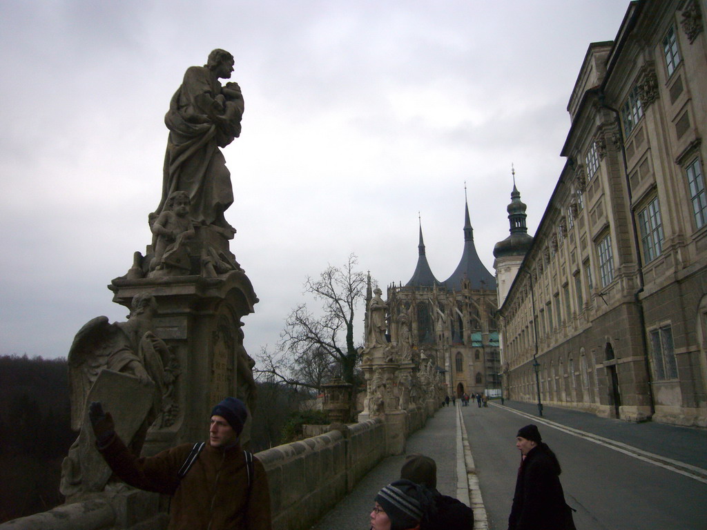 Our tour guide with a statue on the road along the Jesuit College, to the St. Barbara`s Cathedral