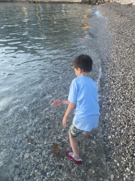 Max throwing stones at the Uvala Lapad Beach, at sunset