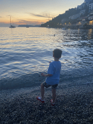 Max throwing stones at the Uvala Lapad Beach, at sunset