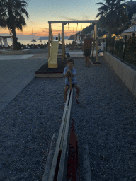 Max on a see-saw at the Uvala Lapad Beach, at sunset
