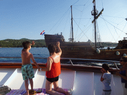 Miaomiao and Max waving at an old ship leaving the Gru Port, viewed from the Elaphiti Islands tour boat