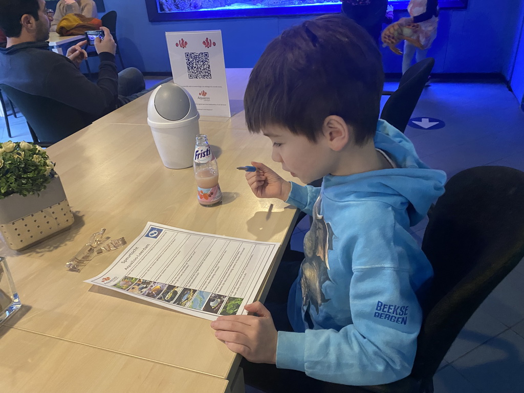 Max doing the scavenger hunt and having a drink at the AquaZoo Leerdam