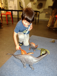 Max playing with dinosaur toys at the Workshop at the Fifth Floor of the Naturalis Biodiversity Center