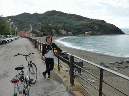 Miaomiao with her bicycle and the beach at the Passegiata a Mare street