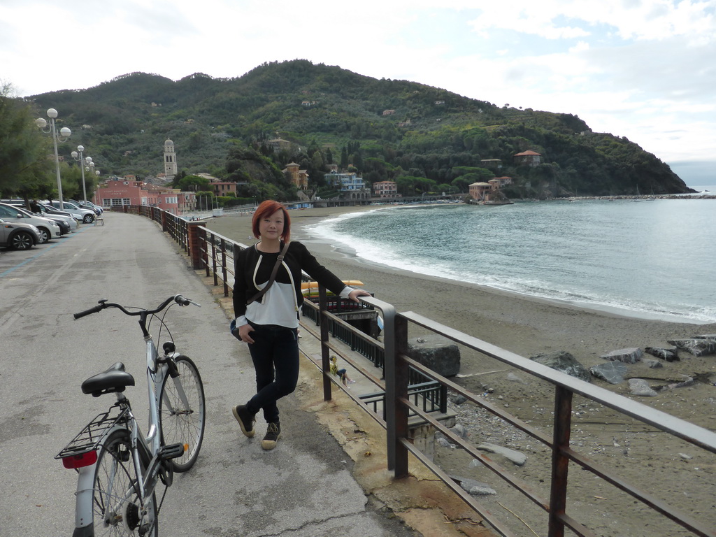 Miaomiao with her bicycle and the beach at the Passegiata a Mare street