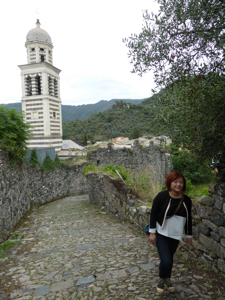 Miaomiao at the path along the City Wall and the tower of the Chiesa di Sant`Andrea church