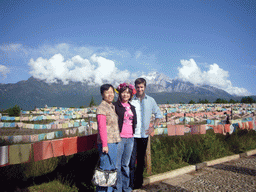 Tim, Miaomiao, Miaomiao`s mother and prayer flags in a Minority Village near Lijiang, with view on Jade Dragon Snow Mountain