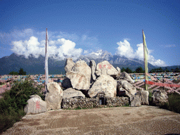Rock with inscriptions in a Minority Village near Lijiang, with view on Jade Dragon Snow Mountain