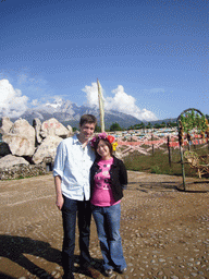 Tim and Miaomiao at a rock with inscriptions in a Minority Village near Lijiang, with view on Jade Dragon Snow Mountain