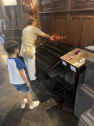 Miaomiao and Max lighting a candle at the Lille Cathedral