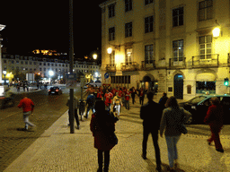 Fans of the S.L. Benfica soccer team celebrating the championship at the Praça Dom João da Câmara square, with a view on the Rossio Square and the São Jorge Castle, by night