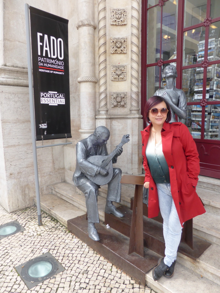 Miaomiao with the statues of fado artists in front of the souvenir shop at the Rossio Railway Station at the Praça Dom João da Câmara square