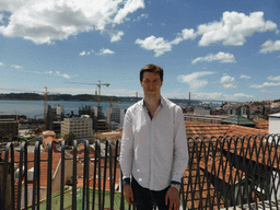 Tim at the Miradouro da Santa Catarina viewpoint, with a view on the Ponte 25 de Abril bridge over the Rio Tejo river and the Cristo Rei statue