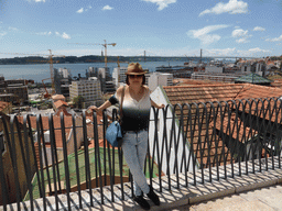 Miaomiao at the Miradouro da Santa Catarina viewpoint, with a view on the Ponte 25 de Abril bridge over the Rio Tejo river and the Cristo Rei statue