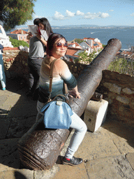 Miaomiao with a cannon at the Praça d`Armas square at the São Jorge Castle, with a view on the southeast side of the city and the Rio Tejo river