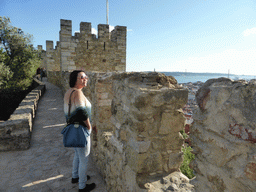 Miaomiao on top of the western wall of the São Jorge Castle, with a view on the Ponte 25 de Abril bridge over the Rio Tejo river and the Cristo Rei statue