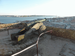 Cannon at the Praça d`Armas square at the São Jorge Castle, with a view on the Ponte 25 de Abril bridge over the Rio Tejo river and the Cristo Rei statue