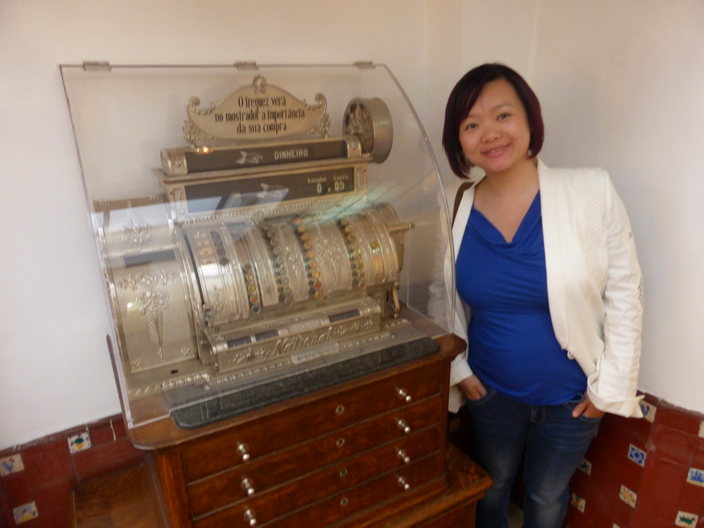 Miaomiao with an old cash register at the Pastéis de Belém restaurant at the Rua Belém street