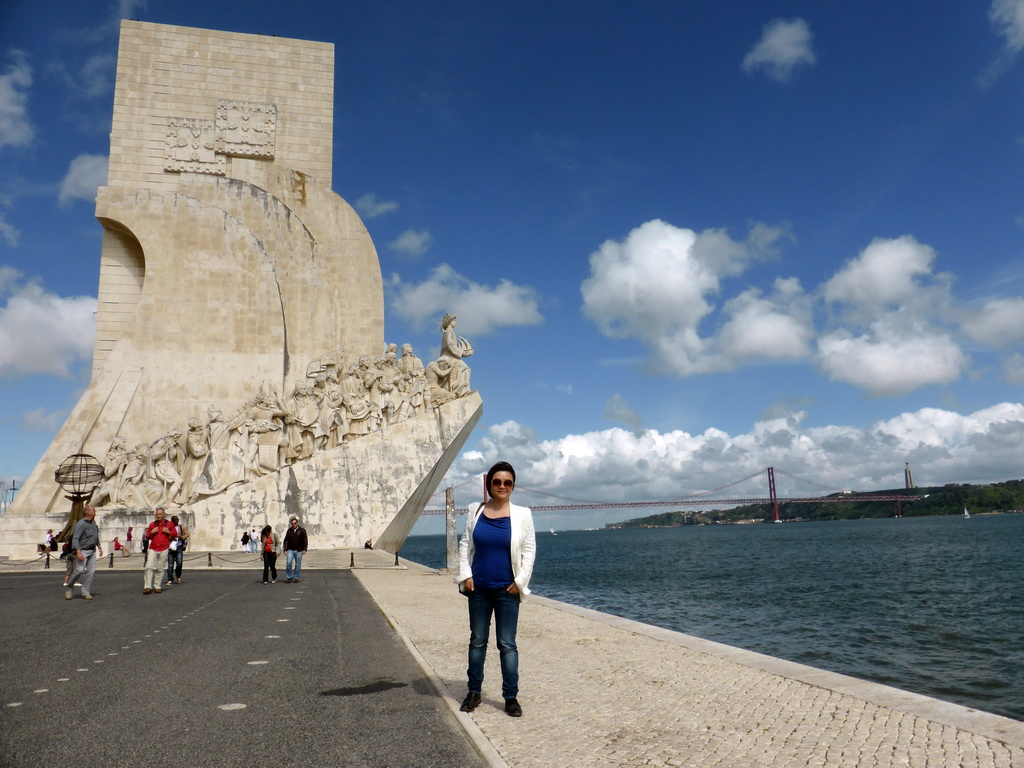 Miaomiao in front of the Padrão dos Descobrimentos monument, the Ponte 25 de Abril bridge over the Rio Tejo river and the Cristo Rei statue