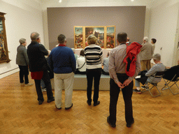 People looking at the triptych `The Temptations of St. Anthony` by Hieronymus Bosch, at the first floor of the Museu Nacional de Arte Antiga museum