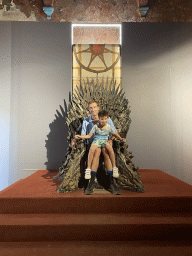 Tim and Max on the Iron Throne from Game of Thrones at the Game of Thrones exhibition at the Lokrum Visitor Center at the southeast side of the Benedictine Monastery of St. Mary