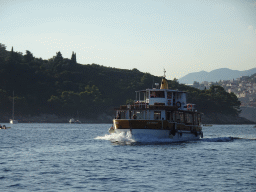 Boat `Zrinski` in front of the east side of Lokrum Island and the Old Town of Dubrovnik, viewed from the ferry to Dubrovnik Harbour