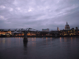 The Millennium Bridge over the Thames river and the dome of St. Paul`s Cathedral, by night