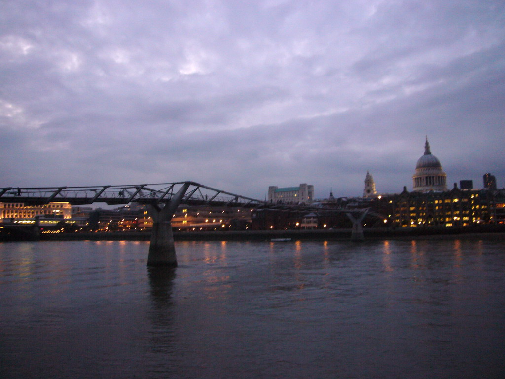 The Millennium Bridge over the Thames river and the dome of St. Paul`s Cathedral, by night