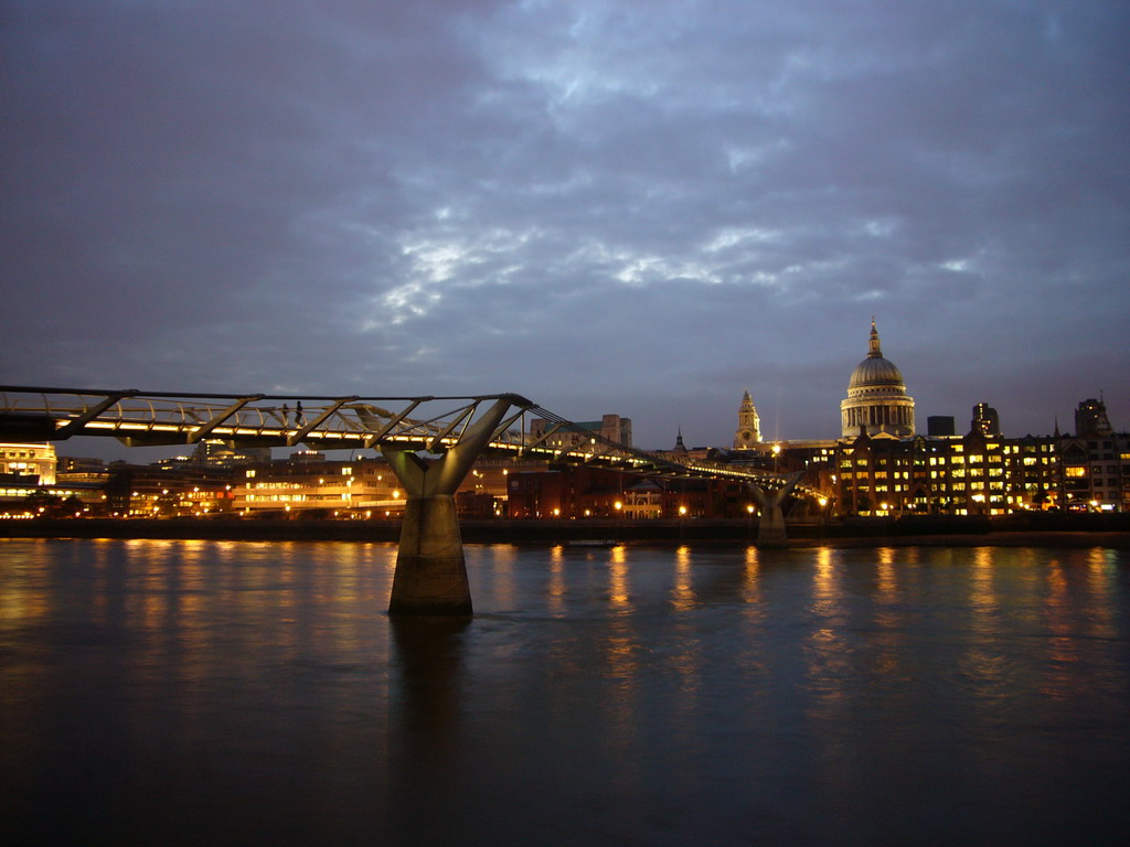 The Millennium Bridge over the Thames river and the dome of St. Paul`s Cathedral, by night