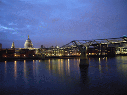 The Millennium Bridge over the Thames river and the dome of St. Paul`s Cathedral, by night