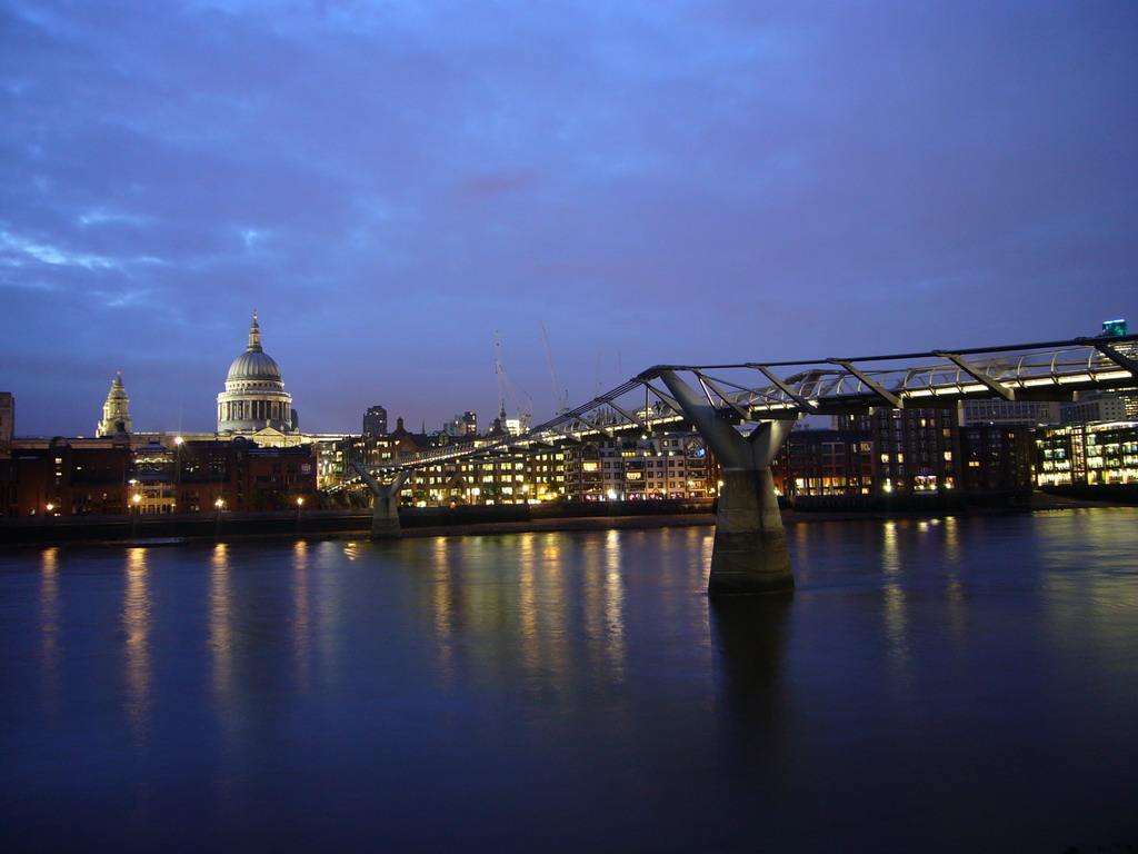 The Millennium Bridge over the Thames river and the dome of St. Paul`s Cathedral, by night