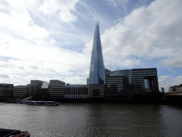 Boats in the Thames river and the Shard building, viewed from the shore on the northeast side of London Bridge