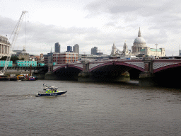 Boats in the Thames river, the Blackfriars Bridge and the towers and dome of St. Paul`s Cathedral, viewed from the Upper Ground