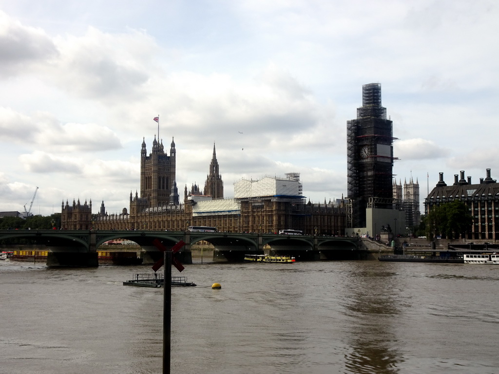 Boats in the Thames river, the Westminster Bridge and the Palace of Westminster with the Big Ben, under renovation, viewed from the Queen`s Walk