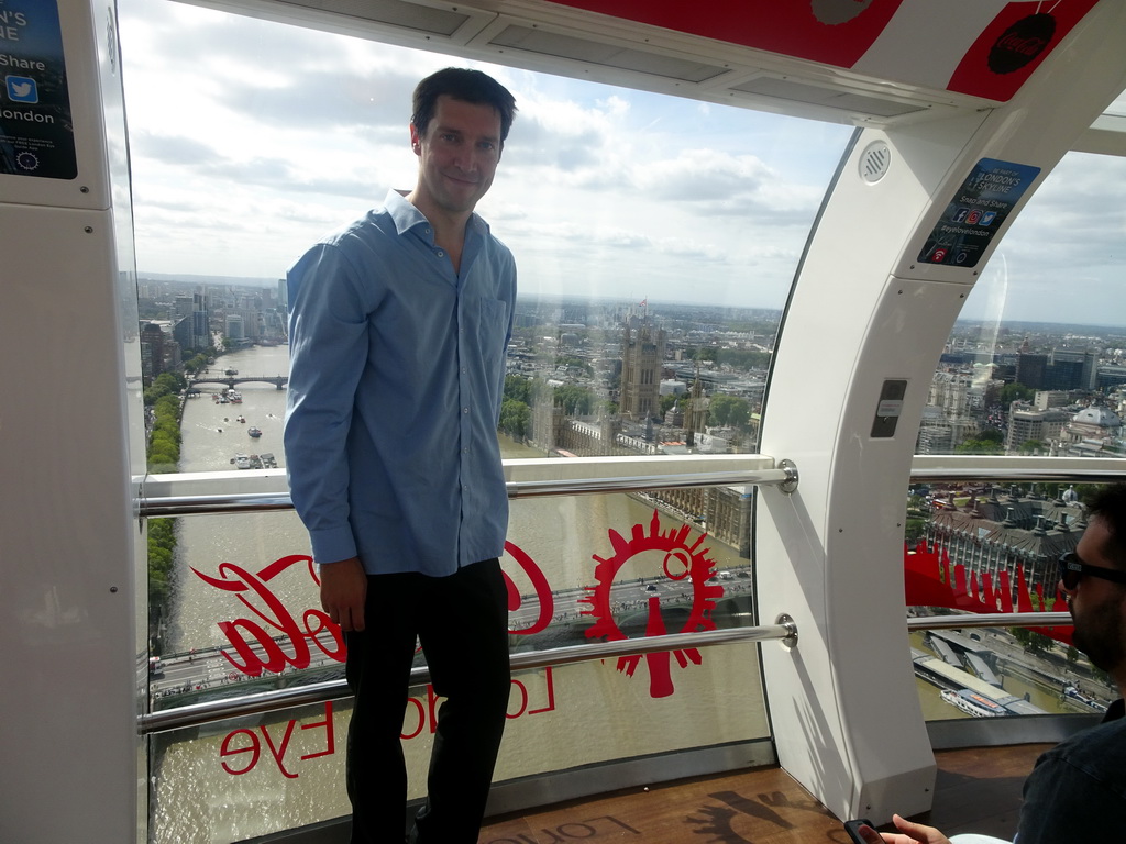 Tim in capsule 17 of the London Eye, with a view on boats in the Thames river, the Westminster Bridge, the Lambeth Bridge and the Palace of Westminster