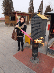 Miaomiao burning incense sticks at the central square of the Nanshan Temple