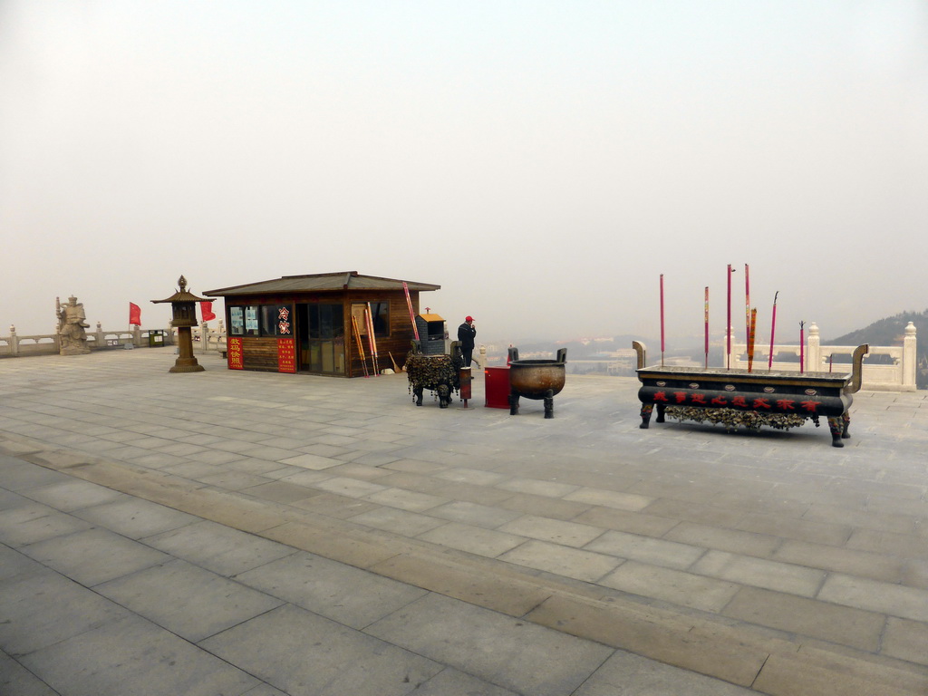 The second highest platform below the Nanshan Great Buddha, with a buddhistic statue, an information stand and incense burners