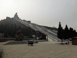 Statue of a hand at the southeastern side of the central square of the Nanshan Temple, and the Nanshan Great Buddha with its staircase