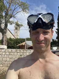 Tim with goggles at the Plaa Grand beach, with a view on the Dominican Monastery & St. Nicholas Church