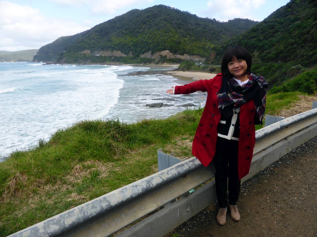 Miaomiao at a viewing point next to the Great Ocean Road, with a view on the coastline at the Cumberland River Holiday Park