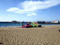 Plastic cars with slides on the Playa de Los Cristianos beach and the Puerto de Los Cristianos harbour