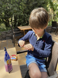 Max eating candy at the terrace of the Snack Bar near the entrance of the Palmitos Park