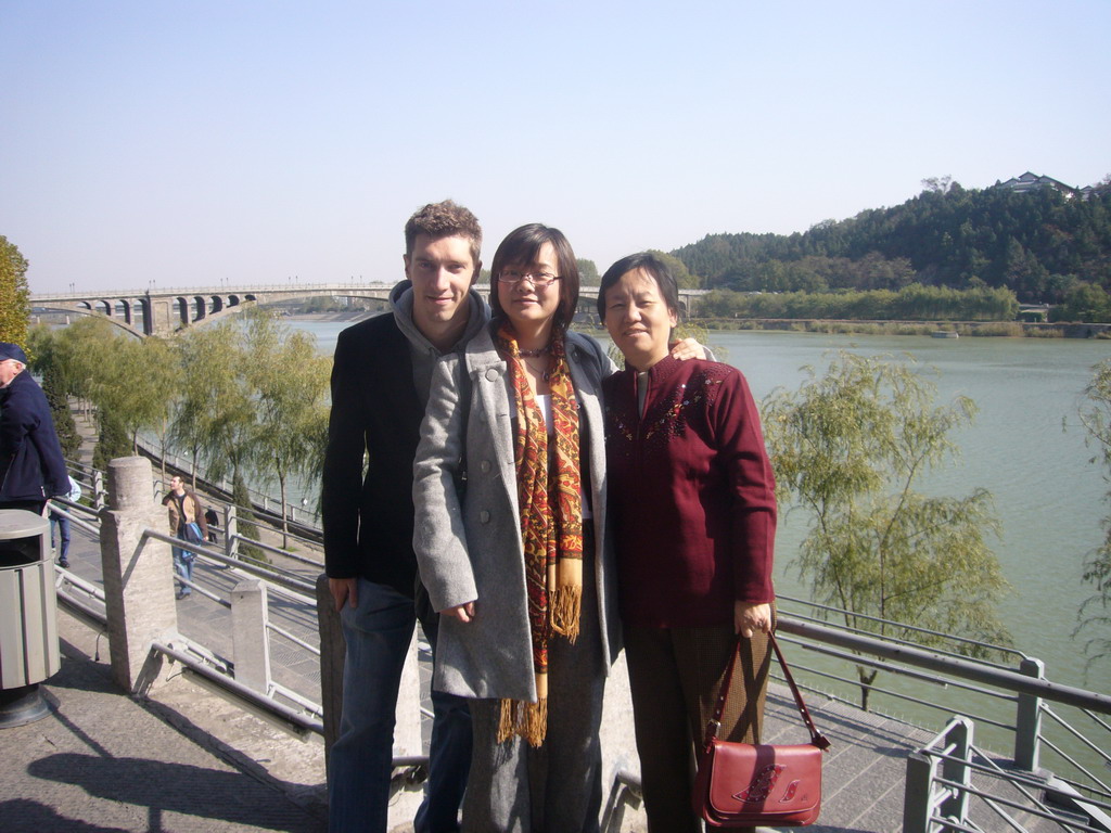 Tim, Miaomiao and Miaomiao`s mother with the Bridge over the Yi River, viewed from the west side of the Longmen Grottoes