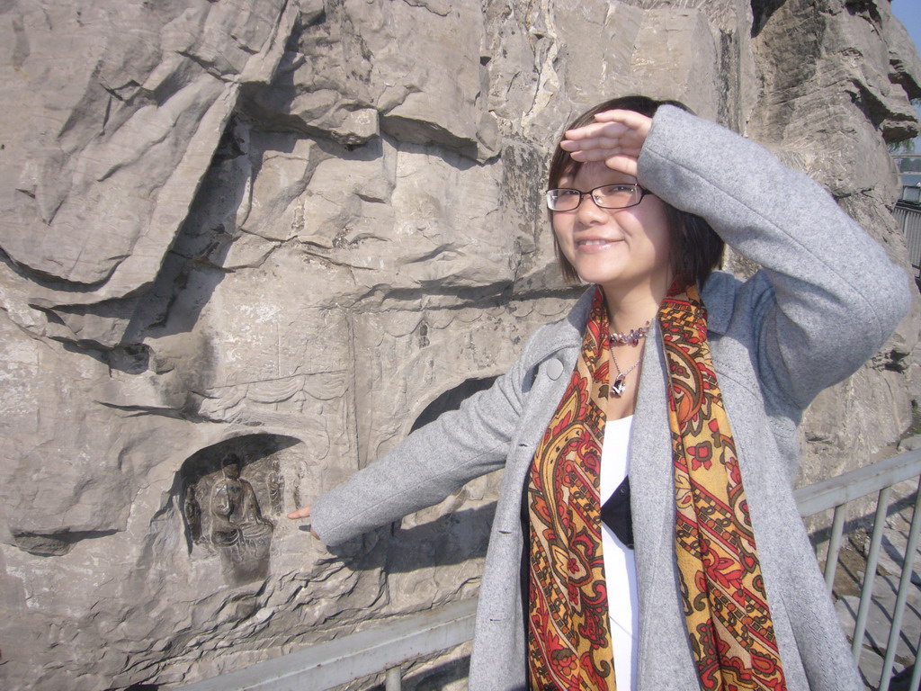 Miaomiao at a niche with a small Buddha statue at the Longmen Grottoes