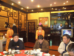 Waitresses and friends at the dinner table in a restaurant near Luoyang